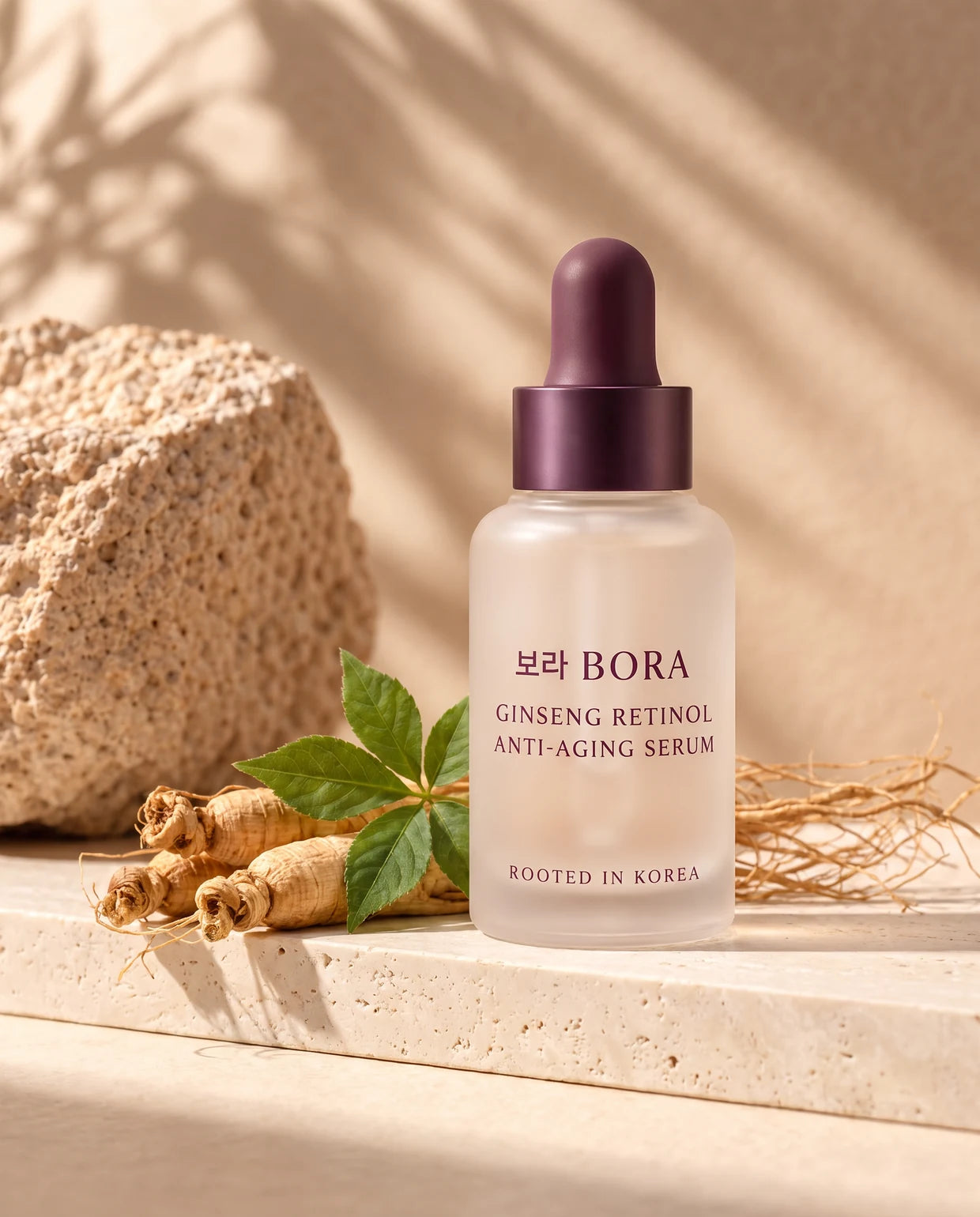 BORA Ginseng Retinol Anti-Aging Serum on sunlit travertine with fresh Korean ginseng roots and leaves